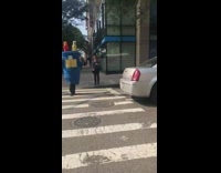 Person dressed as blue charger crossing street