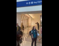 Woman trench coat poses inside the airport