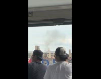 Smoke seen from baseball stadium behind building