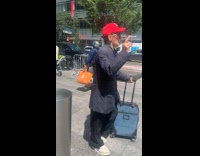 Old man with luggage curses on street