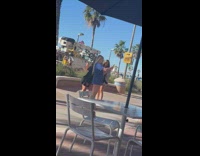 Circle of Ladies Take Selfies Together on Sidewalk