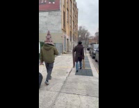 Group walks on street with film props