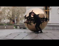 Guy poses with giant gold sphere