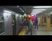 Person carries giant bag of balloons on subway train
