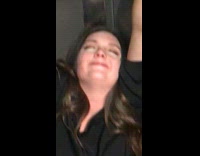 Girl in bathroom stall hanging onto the door and walls