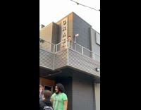 Woman in Green Poses for Photos on Balcony 