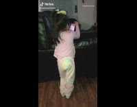 Little girl watches video on phone couch