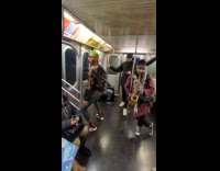 Guy plays saxophone while other guy dance