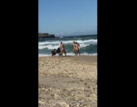 Four men in speedos walk from beach