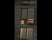 Man masturbates on bed from across apartment window