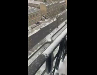 Guy throws snowball off balcony onto driving car 