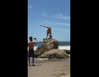 Woman brown white bikini hand stand split rock