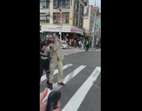 Two men tape the faces together and cross the street
