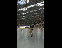 Guy goes under yellow belt barrier airport 