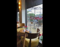 Two girls selfie restaurant patio white umbrella 