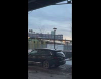 Person laying atop a departing subway train 
