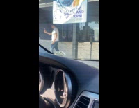 Man white shirt films outside the store