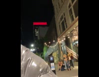 Six people dances together on the sidewalk