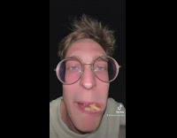 Man Eats Bear-Shaped Bread on Leaves