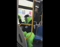 Grinch sits on bus in black outfit