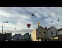 Hot air balloons fiesta fly over houses 