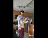 Guy white shirt thumbs up flowers in kitchen