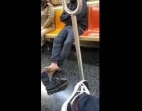 Guy on subway takes blue shoes off 