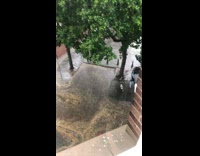 Guy laying down on back on street while it is raining heavily outside 
