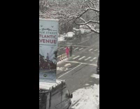 Pink suit guy yells into white megaphone 