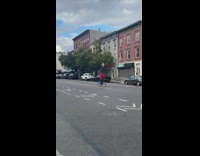 Man rides bicycle with basket and guitar on head