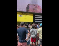 Spiderman sits in chair near crowd 