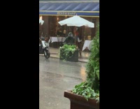 Black helmet guy restaurant patio table rain