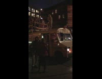 Lady on bus rooftop talks into microphone 