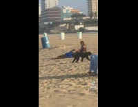 Guy does backflip next to girl on beach flirting 