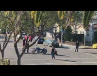 Two kids ride toy motorcycle circles road