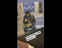 Guy eats with his hands in subway 