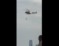 Man hang from helicopter pier yoga