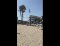 People on paddle boards practice paddling on sand 