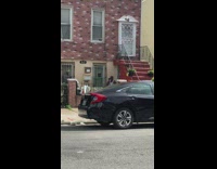 Guy sings karaoke outdoors next to apartment entrance 