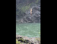 Woman bikini stand rock side near waterfalls