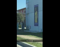 Girl takes picture in front of Kobe Bryant sign