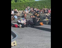 Woman black outfit sits on public park stairs