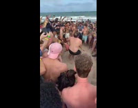 Two people do football drill and big guy throws small guy in sand