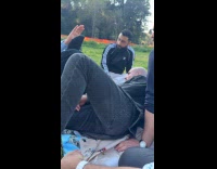 Friend pokes guy laying down at park