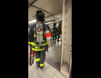 Three firemen carry fire extinguisher in subway