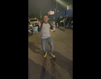 Guy with glasses dances to Latin music at night 