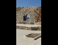 Man gray shirt sit window hole bricks