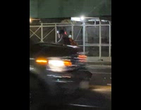 Guy rides scooter with luggage behind him 