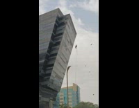 Window cleaner hang from building pushed by water pressure