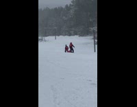 Woman lie down on a sled led by rescuers